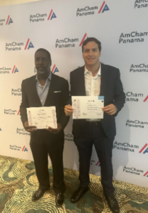 Dos participantes reciben sus certificados de reconocimiento durante la ceremonia de clausura del programa de liderazgo de AmCham Panamá.